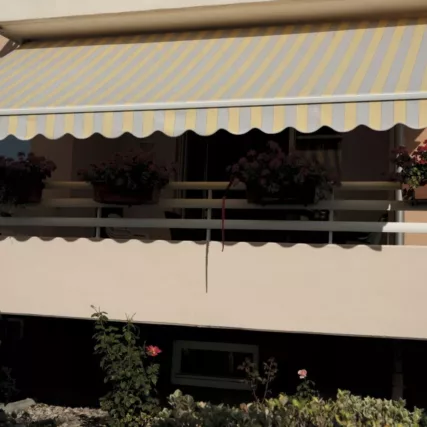 Store banne installé sur balcon à Avallon, offrant une protection solaire moderne et fonctionnelle
